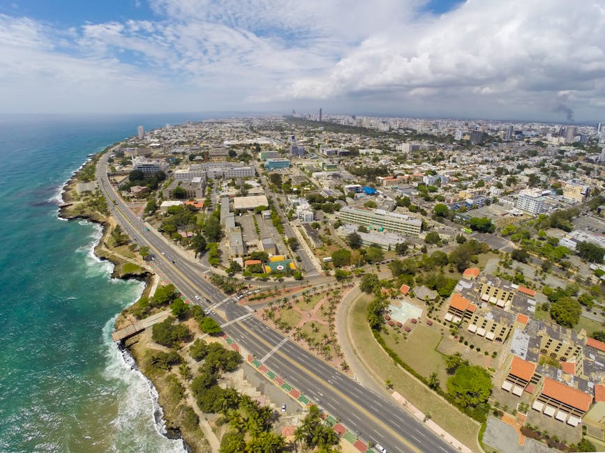 Santo Domingo coastline and city skyline viewed from above, showing dense urban blocks meeting the Caribbean Sea