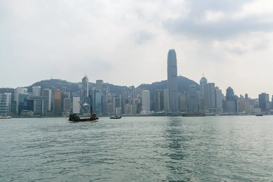Hong Kong skyline across Victoria Harbour with traditional junk boat