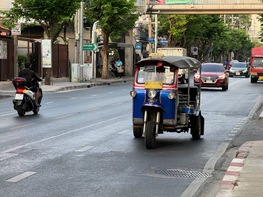 Bangkok street scene with a traditional Thai tuk-tuk and city traffic