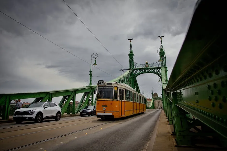 Yellow Budapest tram crossing the Liberty Bridge over the Danube