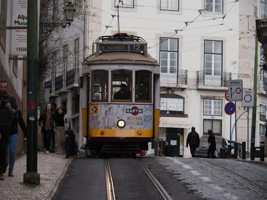 Classic yellow tram climbing a cobbled street in Lisbon's Alfama district, Portugal