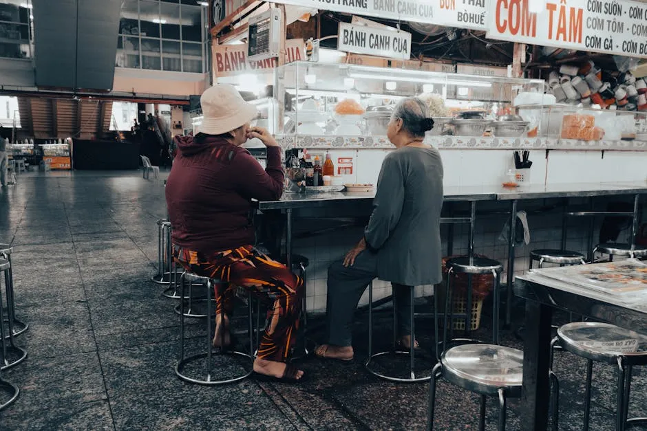 Two people dining at a casual Vietnamese market stall in Ho Chi Minh City