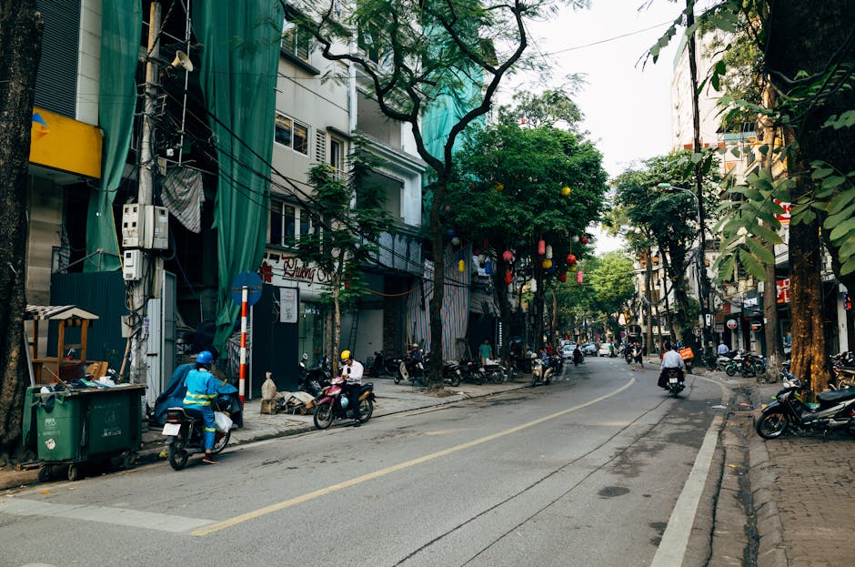 Vibrant Hanoi street scene with motorbikes and trees in Vietnam